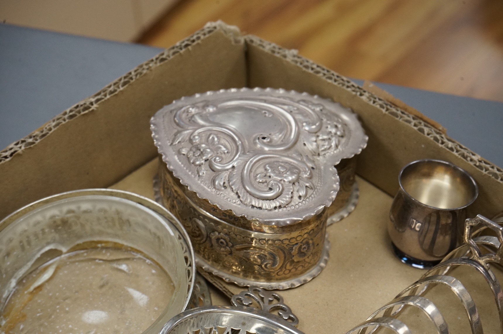 A group of small collectable silver including a late Victorian heart shaped trinket box, Chester, 1899, length 92mm (a.f.), a coaster, toast rack, spill vase, small trinket box, a pair of two handled dishes, napkin ring,